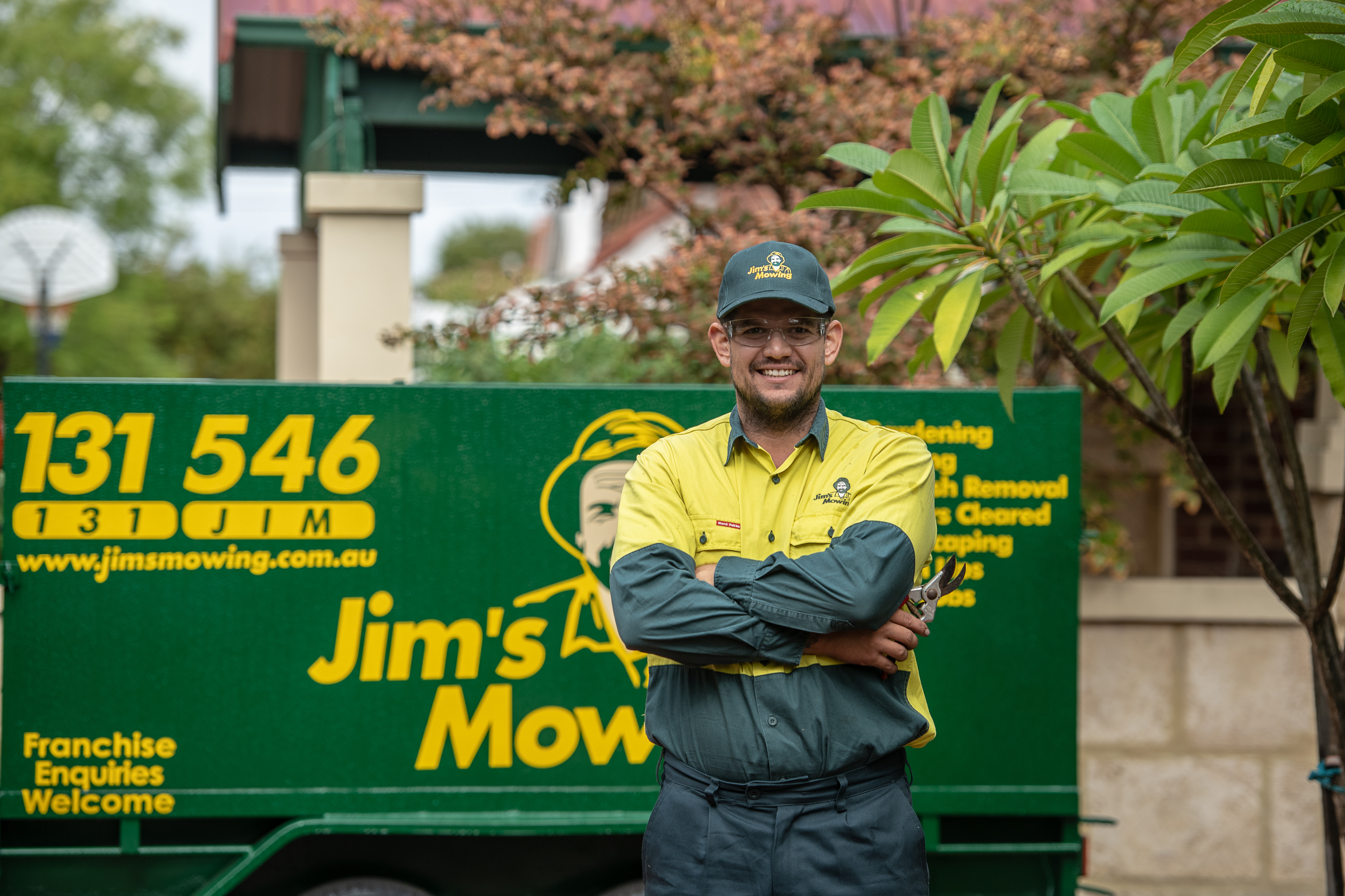 Jim's Mowing team member Standing in front of Jim's Mowing Container